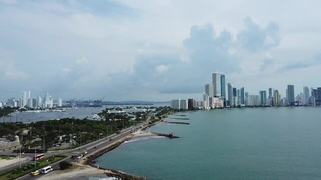 Footage of City sky Line in port of Cartagena with slow rotation towards oldy city and fort done by drone from high above.
