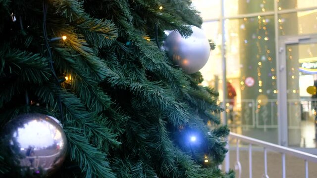 Close-up of a beautiful Christmas tree decorated with christmas balls and garlands on street