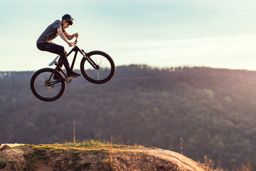 Young man flying through the air on a mountain bike