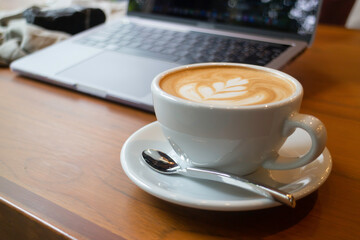 Cup of coffee and laptop on the table