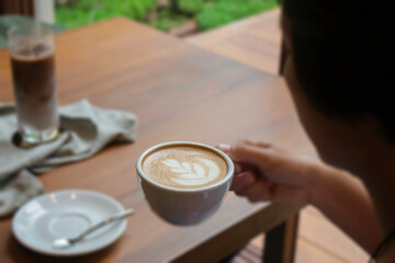 Hot coffee on hand of woman