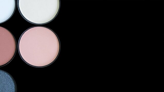 Multicolored beautiful brown eyeshadow palette on black background. Isolated. Beauty products. Makeup cosmetics. Trendy eye shadow, face blush. Bright colorful stop motion animation. Looping video.