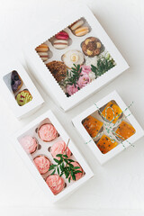 Vibrant colorful sweets in white windowed boxes. Top view.