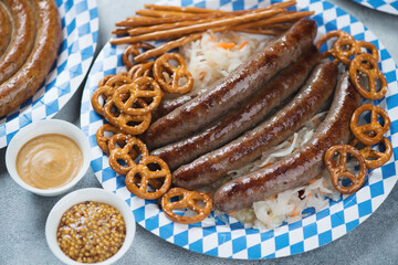 German snack with fried sausages, pretzels, sticks, sauerkraut and mustard, closeup, studio shot