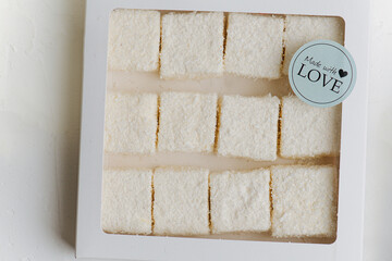 White turkish delight under coconut shavings in a windowed box. Top view.