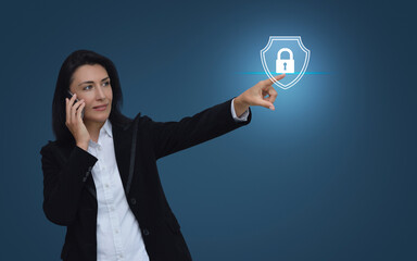Caucasian businesswoman talking on her cell phone and pointing to padlock with shield flat icon over gradient light blue background, Technology security insurance online concept