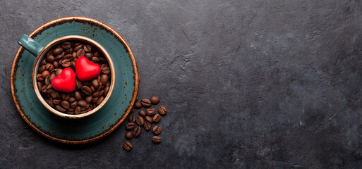 Heart shaped candies over coffee beans in cup. Valentines day card