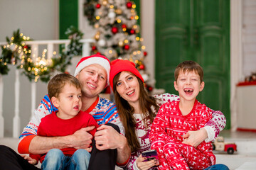 family celebrates christmas at home. Christmas family photo session. Family before christmas in beautiful pajamas