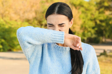 Young woman suffering from allergy outdoors