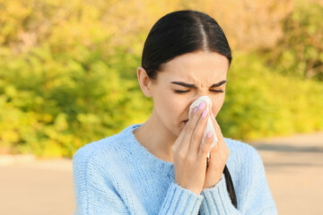 Young woman suffering from allergy outdoors