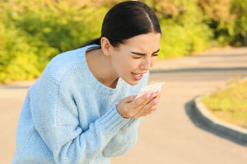 Young woman suffering from allergy outdoors