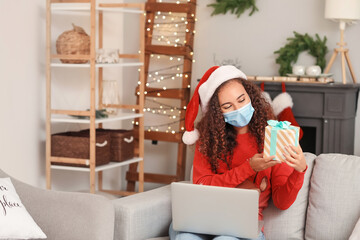 Young African-American woman celebrating Christmas at home due to coronavirus epidemic