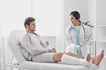 Young man with broken leg visiting doctor in clinic