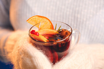 Woman with tasty mulled wine, closeup