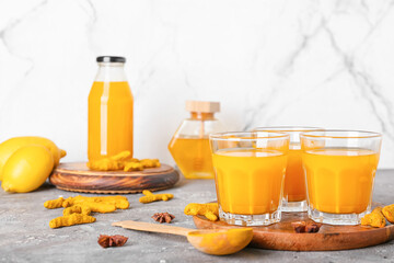 Glasses of healthy turmeric drink on table