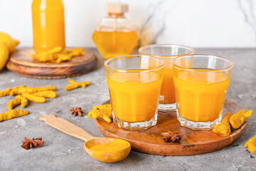 Glasses of healthy turmeric drink on table