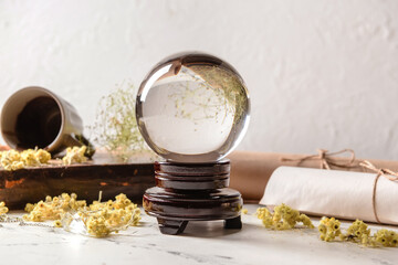 Crystal ball of fortune teller, spell book and scrolls on table