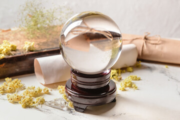 Crystal ball of fortune teller, spell book and scrolls on table