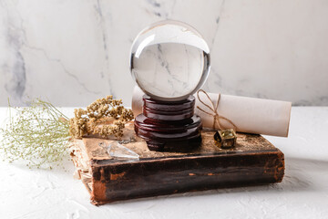 Crystal ball of fortune teller, spell book and scroll on table