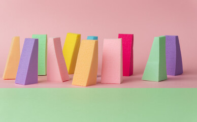 Top view of multi-colored sponges on different pastel-colored backgrounds. Abstract image