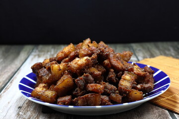 Deep fried cutting fresh pork belly seasoning with flour, soy sauce and pepper on the plate. Famous crispy snack and appetizer menu in party. 