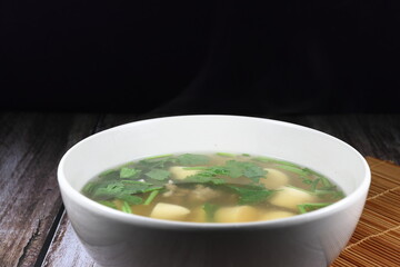 Hot clear soup of egg tofu and minced pork seasoning with spring onion and coriander in the bowl. Famous soft and light menu in Asia restaurant. Food for easy digestion concept. 