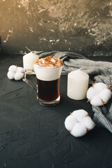 Warm knitted sweater,cup of hot coffee and candle on dark backdrop - 392786621