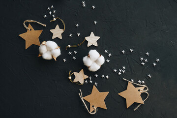 Decorative stars and white cotton on a black background, top view. Flat lay composition - 392786657