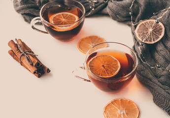 Cozy autumn or winter at home. A cup of tea, lemon, garland on a white table near gray warm sweater - 392786873