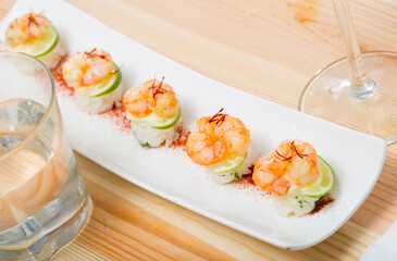 Seafood appetizer. Roasted shelled prawns on rice served with saffron and lime slice