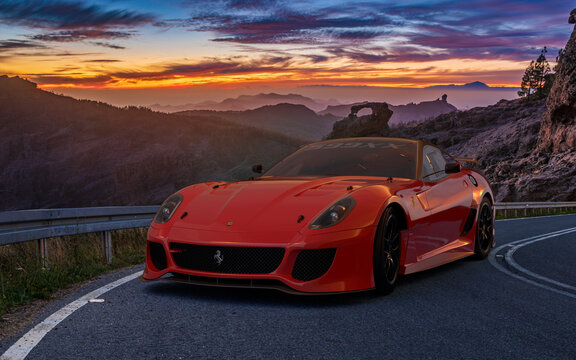 Sporty Ferrari 599 on a beautiful road at sunset
