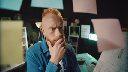 Portrait of stressed red hair man selecting right decision in hipster office.