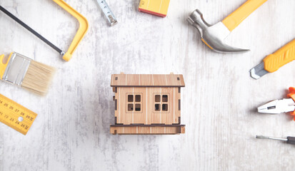 Work tools with a wooden house model.