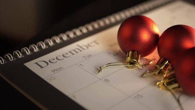 Red baubles on calendar at Christmas close up panning shot
