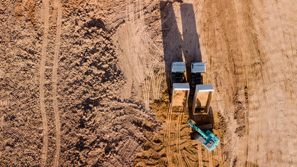 Construction site aerial view There are backhoes and dump trucks shoot from drone fly