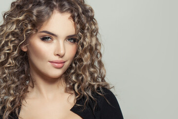 Cute young model woman with curly hair on white, fashion beauty portrait