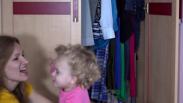 Mother play hide game with daughter in closet. Free time and childhood 4K