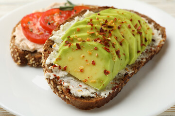 Tasty toasts with avocado and tomato on white background