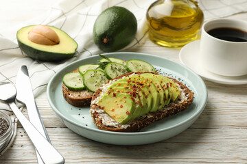 Concept of breakfast with toasts with avocado and cucumber on wooden table
