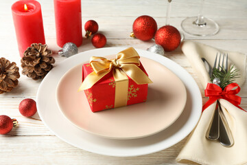 Concept of New year table setting with gift box on wooden table
