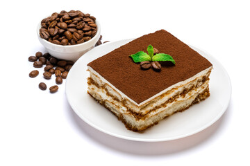 Traditional Italian Tiramisu square dessert portion on ceramic plate and coffee beans isolated on white background with clipping path