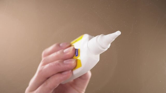 A person applies PVA glue and glues a piece of cardboard.