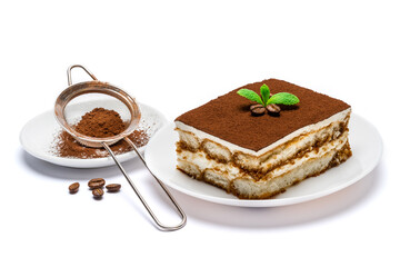Traditional Italian Tiramisu square dessert portion on ceramic plate and strainer with cocoa powder isolated on white