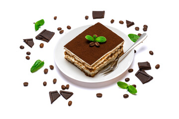 Traditional Italian Tiramisu square dessert portion on ceramic plate, pieces of chocolate bar and...
