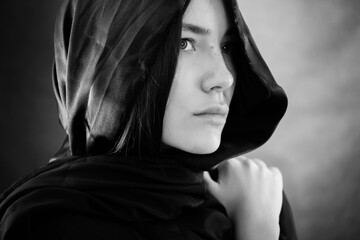 Young woman wearing hijab on black.