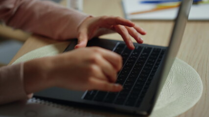Fototapeta na wymiar Girl hands typing computer keyboard indoors. Kid using laptop for schooling.