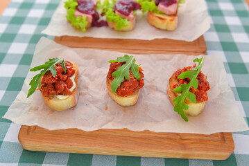 Juicy fresh Italian bruschetta over green plaid table cloth. Traditional Italian cuisine concept.