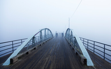 Fototapeta premium Umea, Norrland Sweden - September 27, 2019: bridge in fog with cyclists