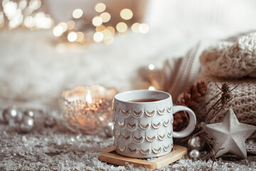Cozy winter background with a beautiful cup, decor details and bokeh copy space.