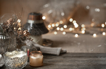 Cozy winter background with details of home decor on a blurred background with lights copy space.
